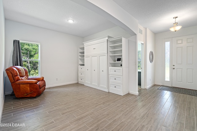 entrance foyer featuring a textured ceiling and light hardwood / wood-style floors