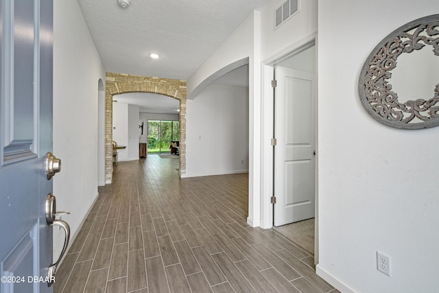 hallway featuring a textured ceiling and hardwood / wood-style flooring