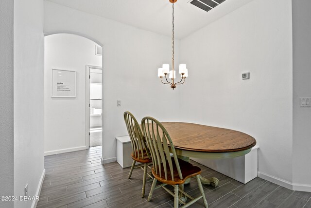 dining space with dark hardwood / wood-style flooring and a notable chandelier