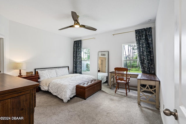 carpeted bedroom featuring multiple windows and ceiling fan