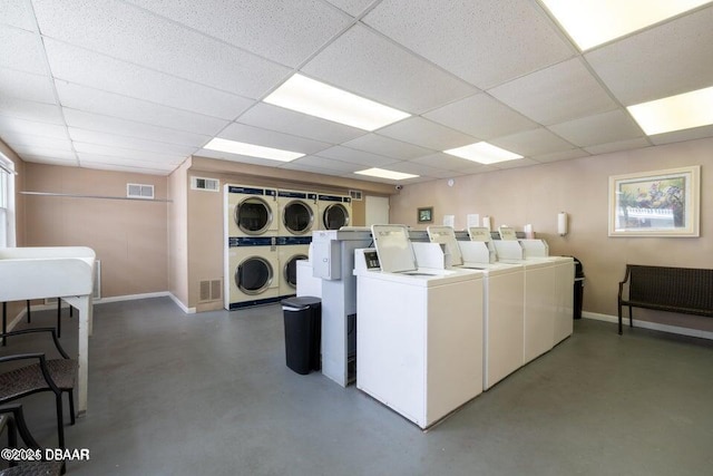 shared laundry area featuring visible vents, baseboards, washing machine and dryer, and stacked washing maching and dryer