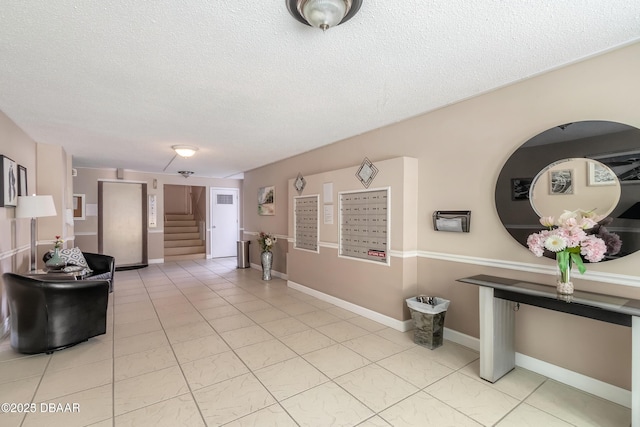 interior space with stairway, baseboards, and a textured ceiling