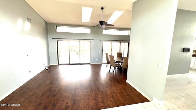 unfurnished living room with light hardwood / wood-style flooring, ceiling fan, and a high ceiling