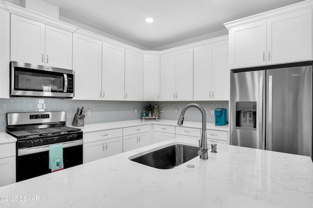 802 Margaritaville Ave, Daytona Beach, FL 32124 - kitchen with appliances with stainless steel finishes, a sink, tasteful backsplash, white cabinetry, and recessed lighting