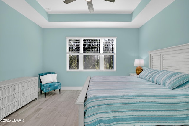 802 Margaritaville Ave, Daytona Beach, FL 32124 - bedroom with wood finished floors, a tray ceiling, baseboards, and a ceiling fan