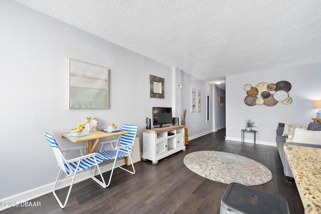 living area featuring a textured ceiling, baseboards, and dark wood-type flooring