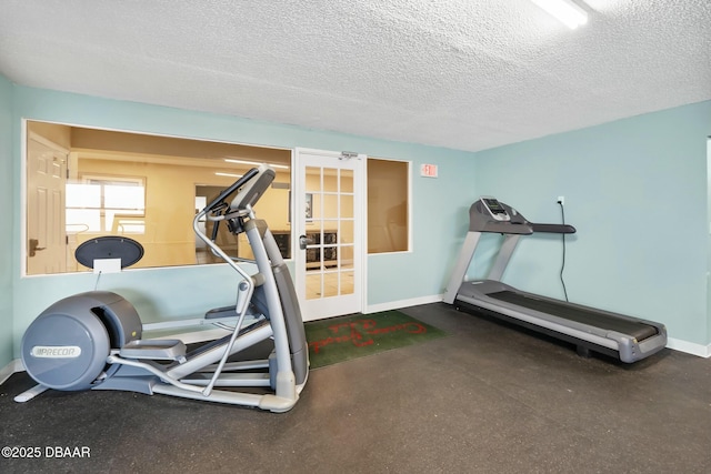 exercise area with baseboards and a textured ceiling