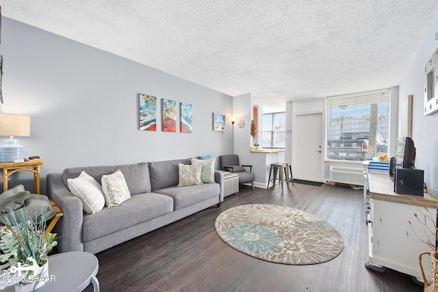 living room featuring a textured ceiling, baseboards, and dark wood-style flooring