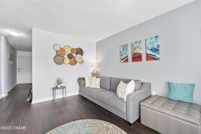 living room featuring dark wood finished floors, a textured ceiling, and baseboards