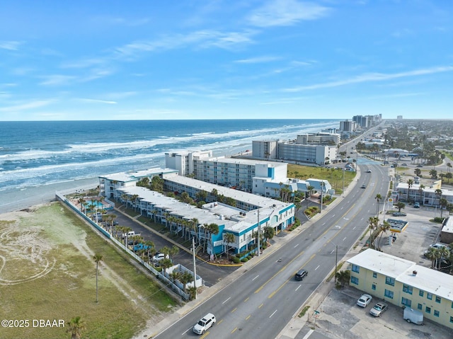 drone / aerial view with a water view, a beach view, and a city view