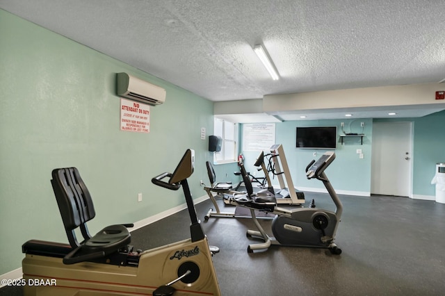 workout area featuring a wall unit AC, a textured ceiling, and baseboards