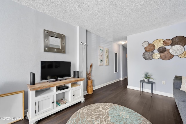 living room featuring a textured ceiling, baseboards, and dark wood-type flooring