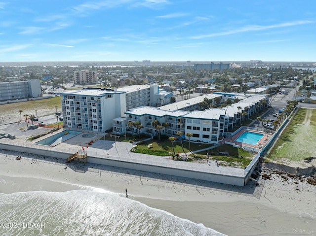 aerial view with a city view, a water view, and a beach view