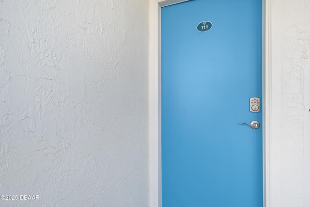 property entrance with stucco siding