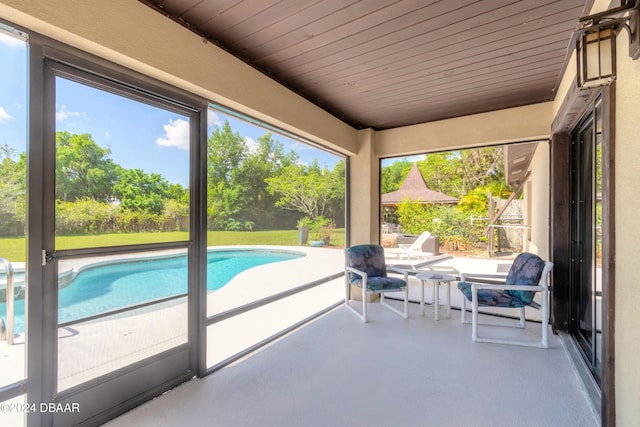 unfurnished sunroom with wood ceiling