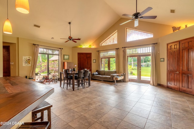 tiled dining area with high vaulted ceiling, french doors, and ceiling fan