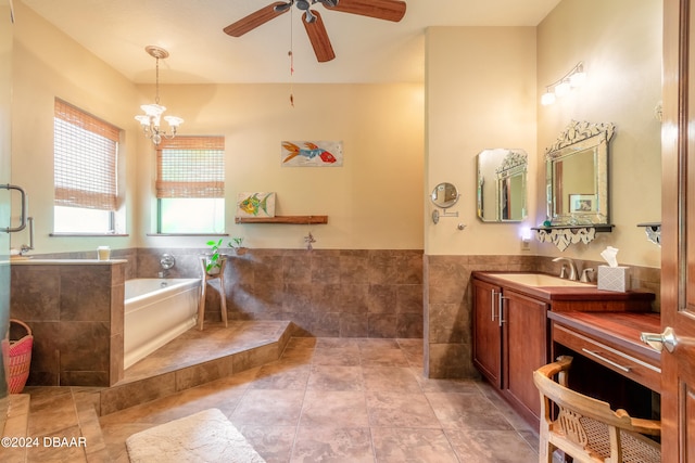 bathroom featuring tile walls, vanity, tile patterned flooring, a tub to relax in, and ceiling fan with notable chandelier