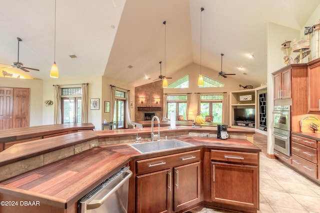 kitchen featuring butcher block counters, high vaulted ceiling, sink, and stainless steel appliances