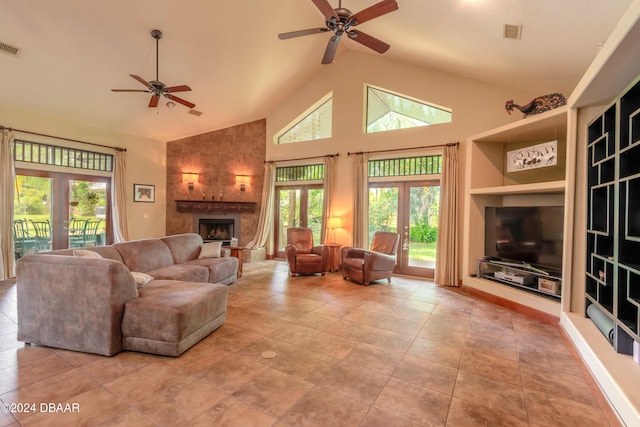 living room with french doors, a tiled fireplace, built in shelves, light tile patterned floors, and ceiling fan