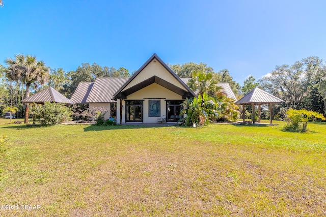 rear view of property with a yard and a gazebo