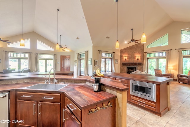 kitchen with high vaulted ceiling, appliances with stainless steel finishes, sink, and plenty of natural light