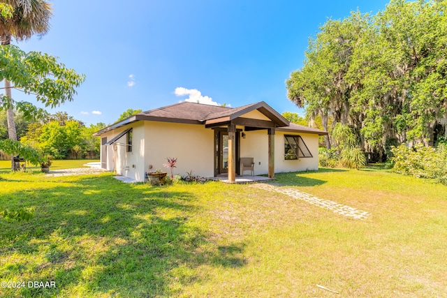 view of front of house with a patio and a front lawn