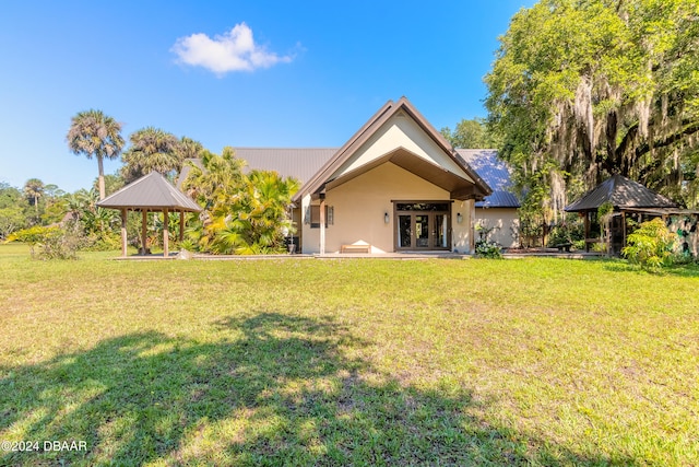 rear view of house featuring french doors, a lawn, and a gazebo