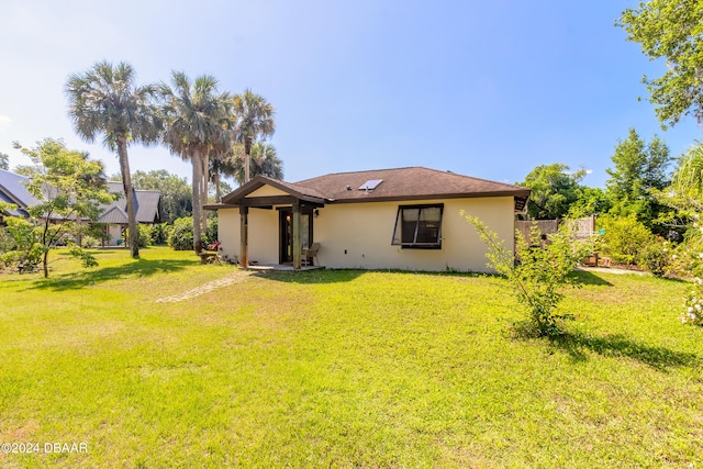 rear view of property with a lawn