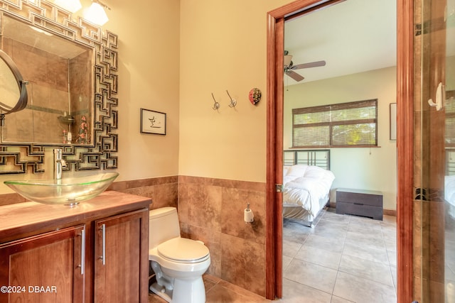 bathroom featuring tile walls, tile patterned floors, vanity, toilet, and ceiling fan