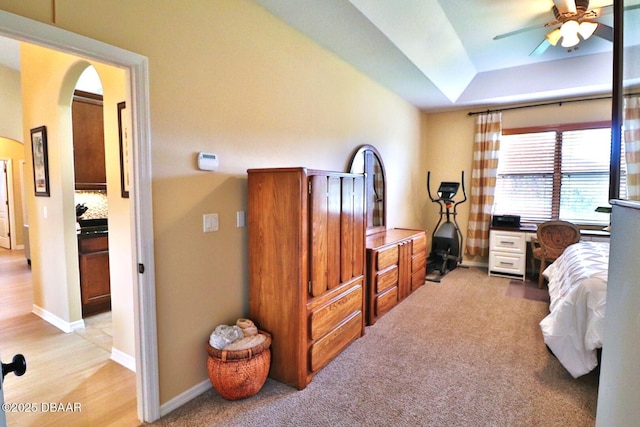 bedroom with a tray ceiling and light carpet