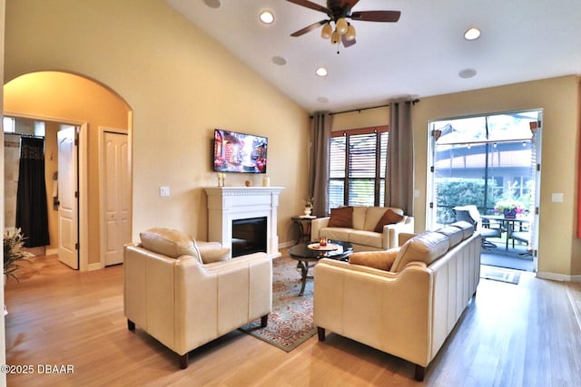 living room featuring high vaulted ceiling, ceiling fan, and light hardwood / wood-style flooring