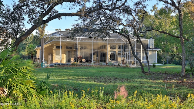 back of house with a lanai and a lawn