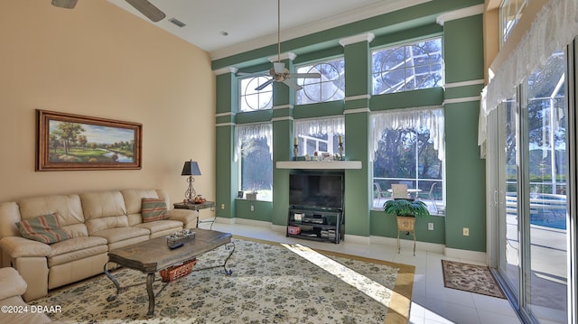 living room featuring a towering ceiling, ceiling fan, and tile patterned flooring