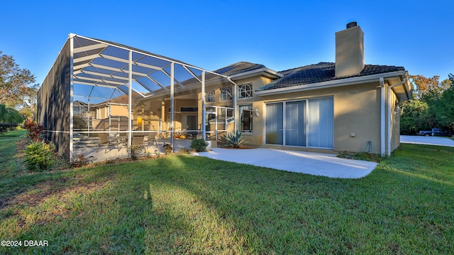 back of house with a patio area, a lawn, and a lanai