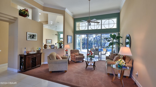 living room featuring ceiling fan, carpet flooring, ornamental molding, and a towering ceiling