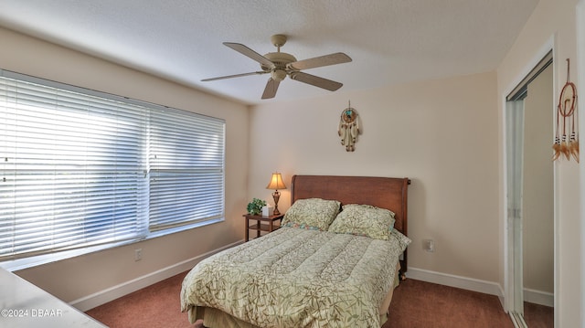 carpeted bedroom with ceiling fan, a textured ceiling, and a closet