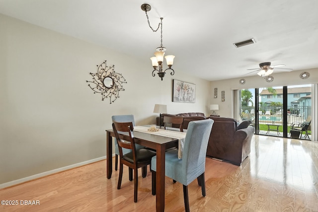 3333 S Ridgewood Ave Unit 8B, Port Orange, FL 32129 - dining space featuring light wood-type flooring, a chandelier, and a ceiling fan
