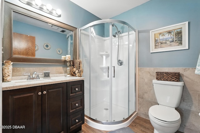 3333 S Ridgewood Ave Unit 8B, Port Orange, FL 32129 - bathroom with tile walls, vanity, a stall shower, wood finished floors, and a wainscoted wall