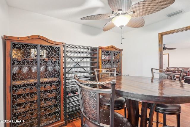 wine room with hardwood / wood-style flooring and ceiling fan