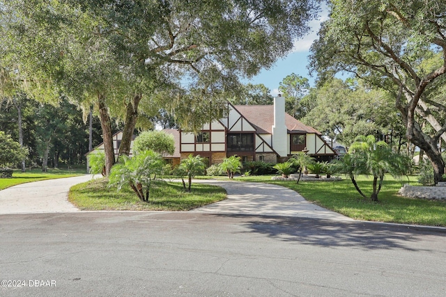 english style home with a front lawn