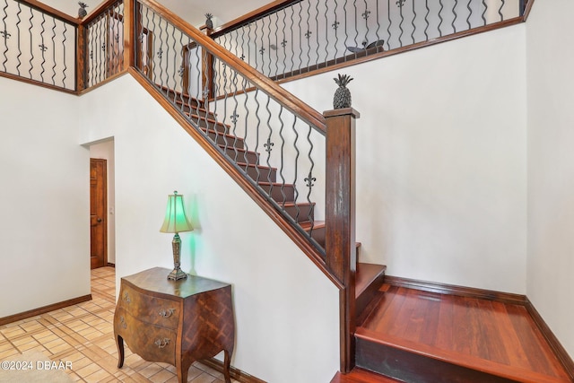 staircase featuring a towering ceiling