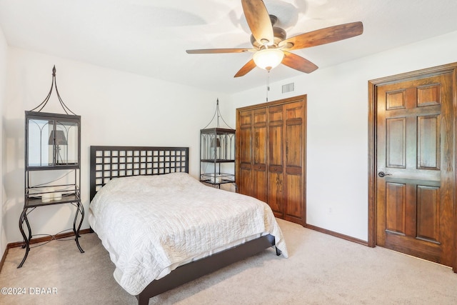 carpeted bedroom featuring ceiling fan and a closet