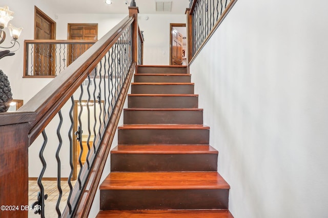 stairway featuring an inviting chandelier