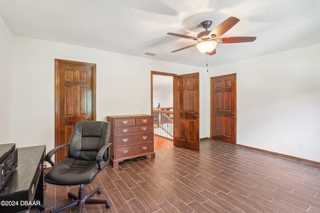 office area with dark hardwood / wood-style flooring, a textured ceiling, and ceiling fan