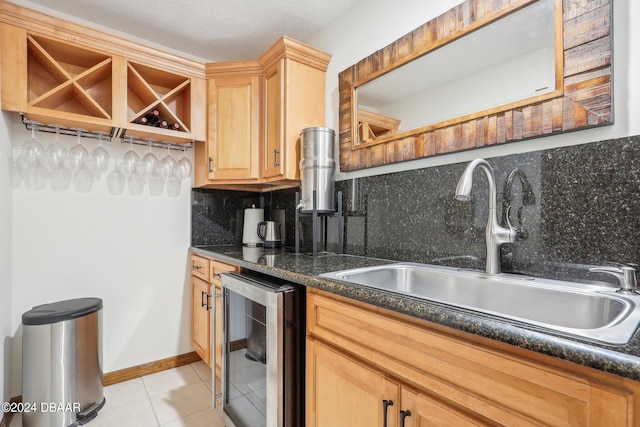 kitchen with tasteful backsplash, wine cooler, light tile patterned floors, light brown cabinetry, and sink