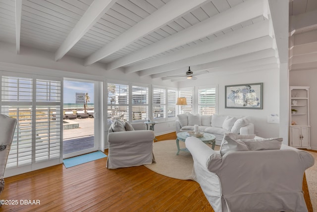 living room with beamed ceiling, hardwood / wood-style flooring, and a ceiling fan
