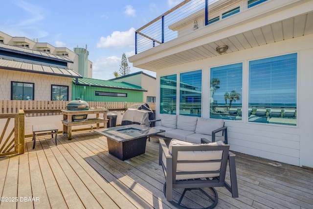 wooden terrace featuring an outdoor living space with a fire pit