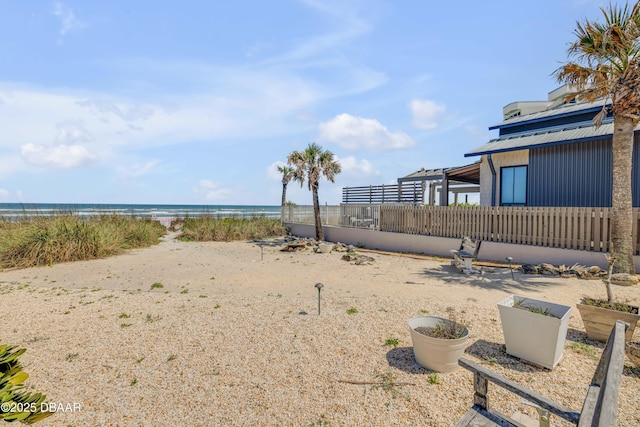 view of yard with a water view and a beach view