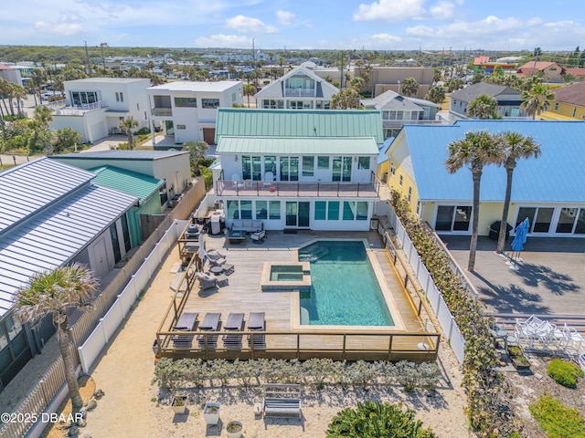 view of swimming pool featuring a fenced backyard, a pool with connected hot tub, and a residential view