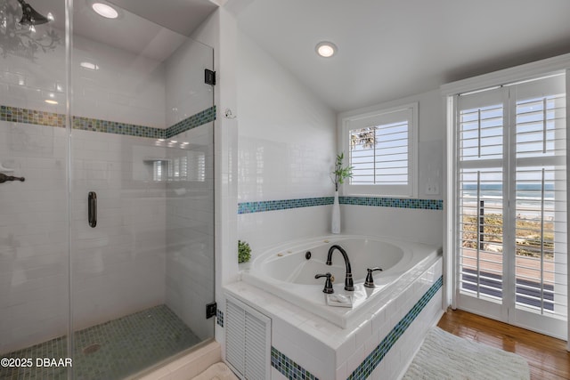 full bathroom with a bath, lofted ceiling, wood finished floors, and a shower stall